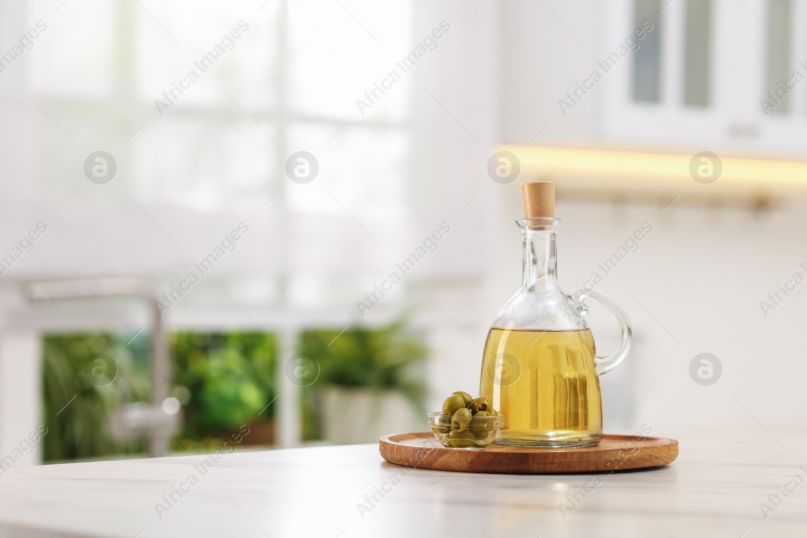 Photo of Vinegar and olives on table in kitchen. Space for text