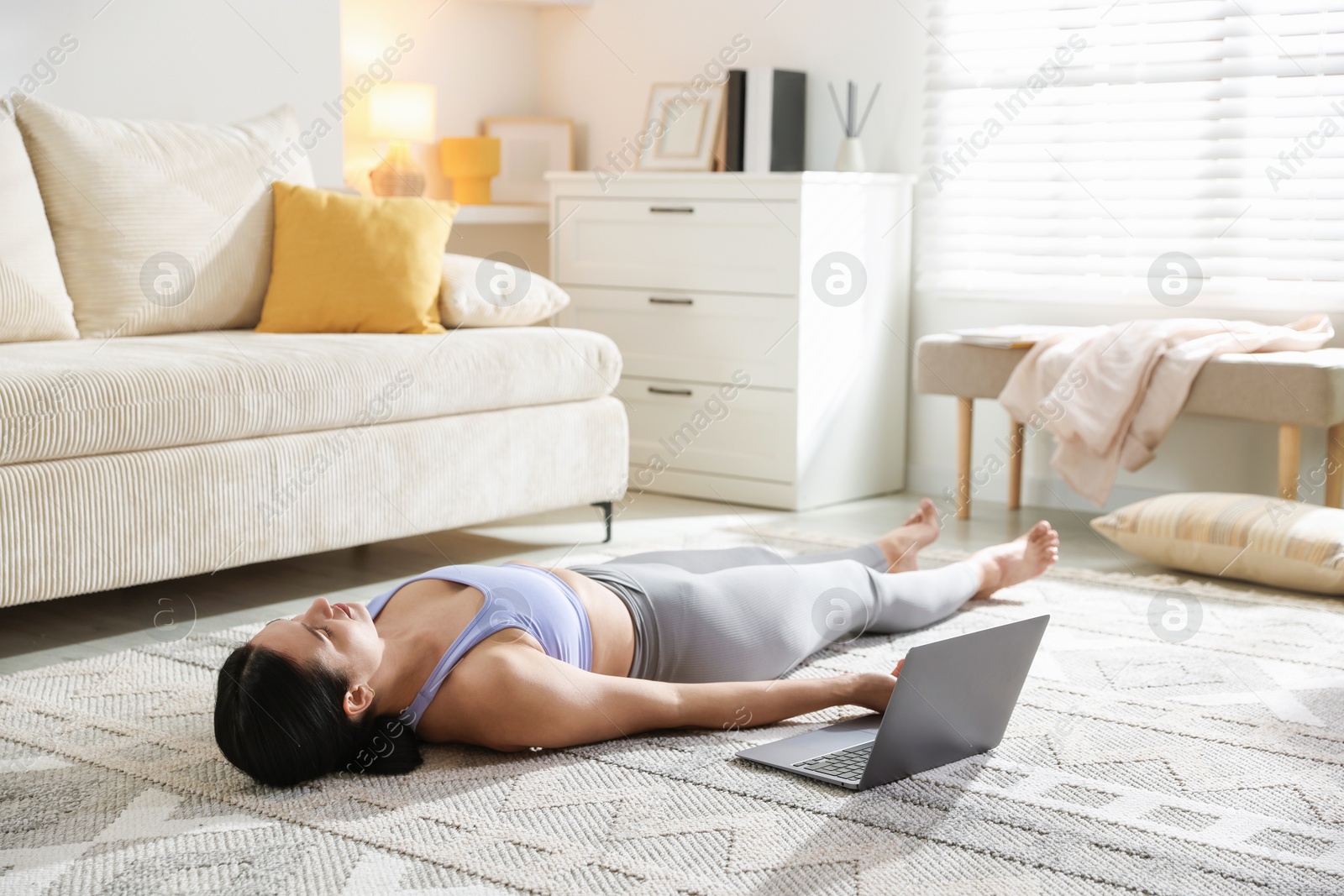 Photo of Woman with laptop meditating on floor at home