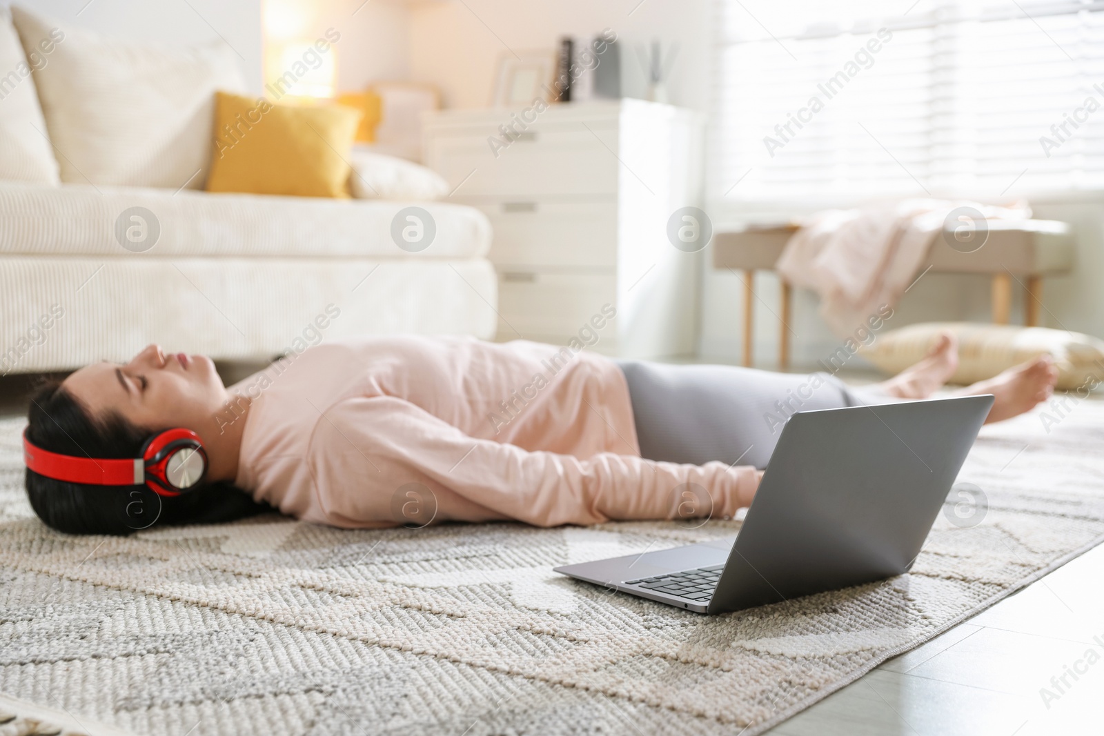 Photo of Woman with laptop meditating on floor at home