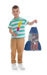 Happy boy with rocket shaped pinata and stick on white background