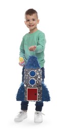 Photo of Happy boy with rocket shaped pinata and stick on white background