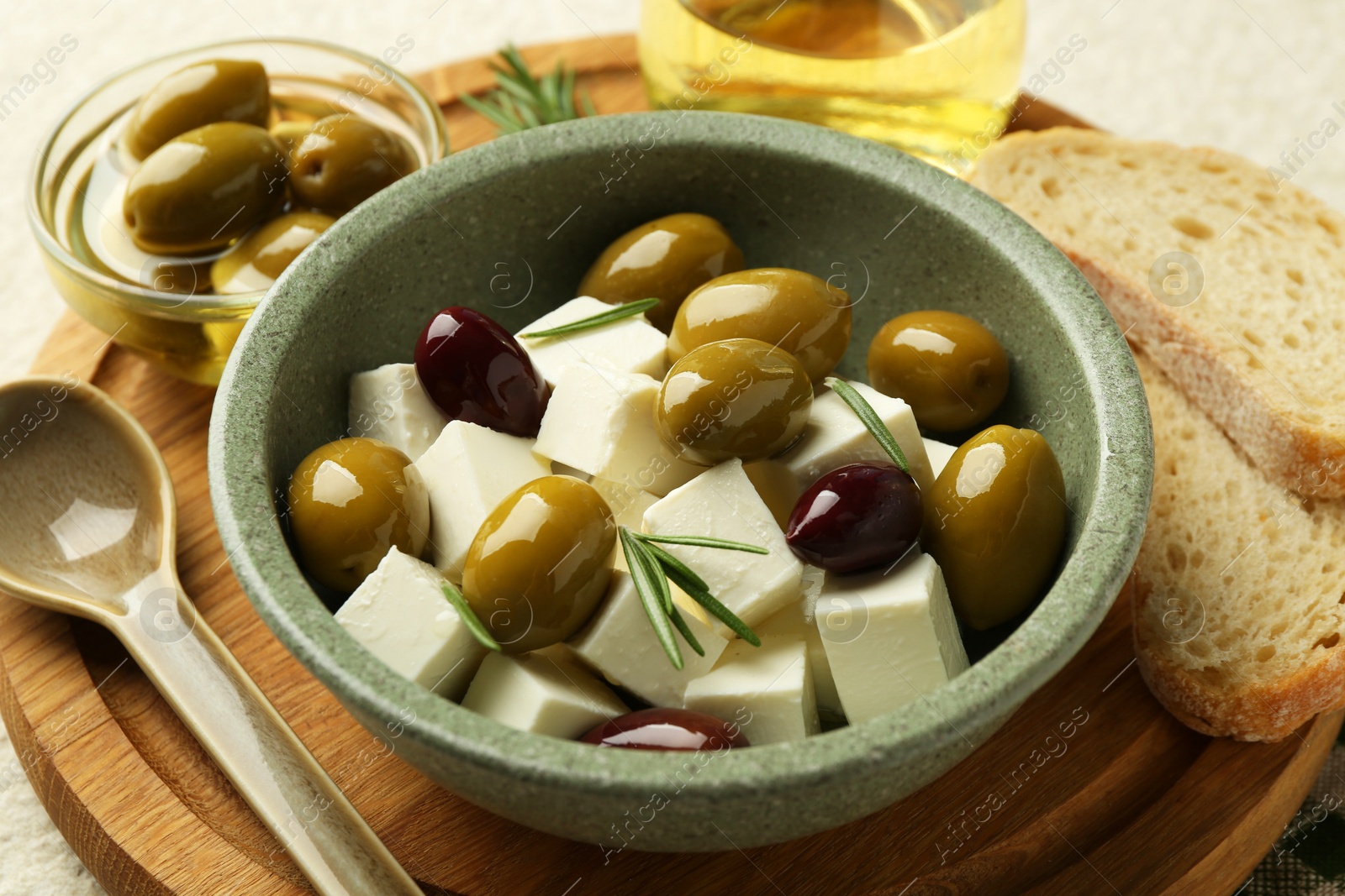 Tasty olives served with feta cheese, oil and bread on table, closeup Photo of Tasty olives served with feta cheese, oil and bread on table, closeup