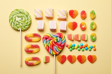 Many different tasty candies and marshmallows on beige background, flat lay