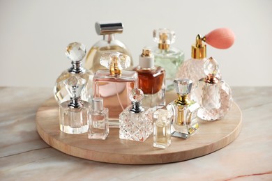 Photo of Different luxury perfumes on color marble table