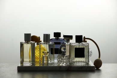Photo of Many different luxury perfumes on grey table