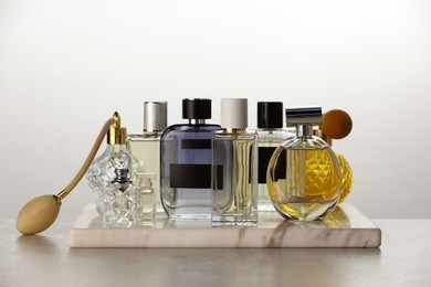 Photo of Many different luxury perfumes on grey table