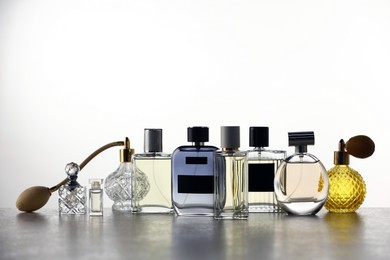 Photo of Many different luxury perfumes on grey table