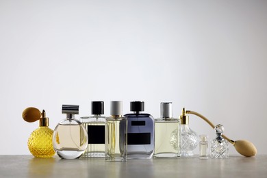 Photo of Many different luxury perfumes on grey table