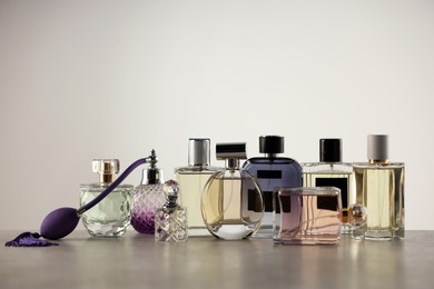 Photo of Many different luxury perfumes on grey table