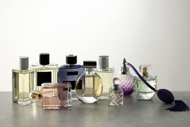 Photo of Many different luxury perfumes on grey table