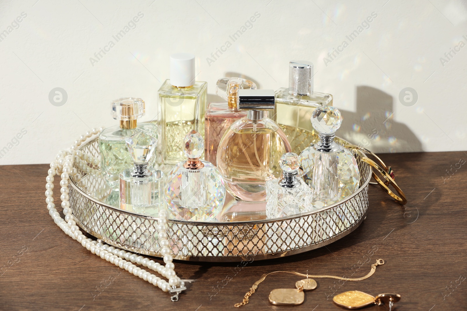 Different luxury perfumes and accessories on wooden table Photo of Different luxury perfumes and accessories on wooden table
