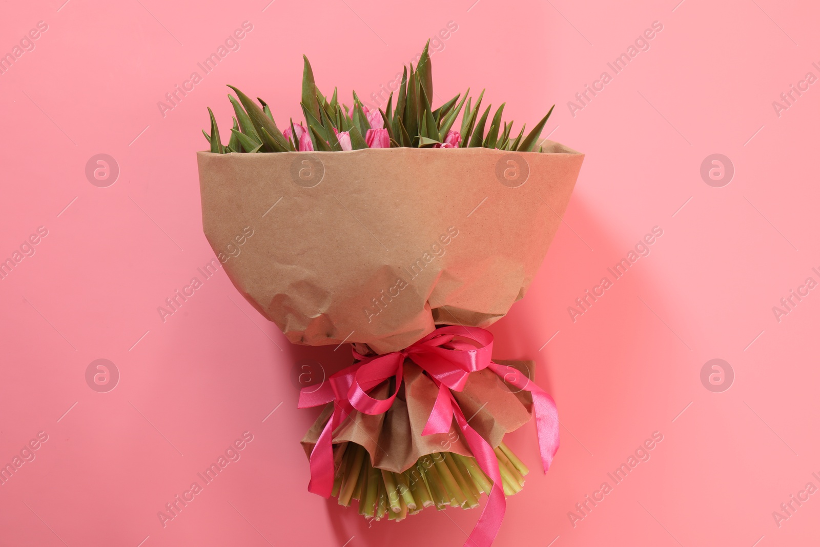 Photo of Bouquet of beautiful tulips on pink background, top view