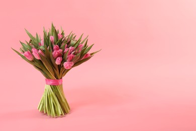 Bouquet of beautiful tulips on pink background, space for text