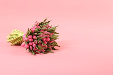 Photo of Bouquet of beautiful tulips on pink background, space for text