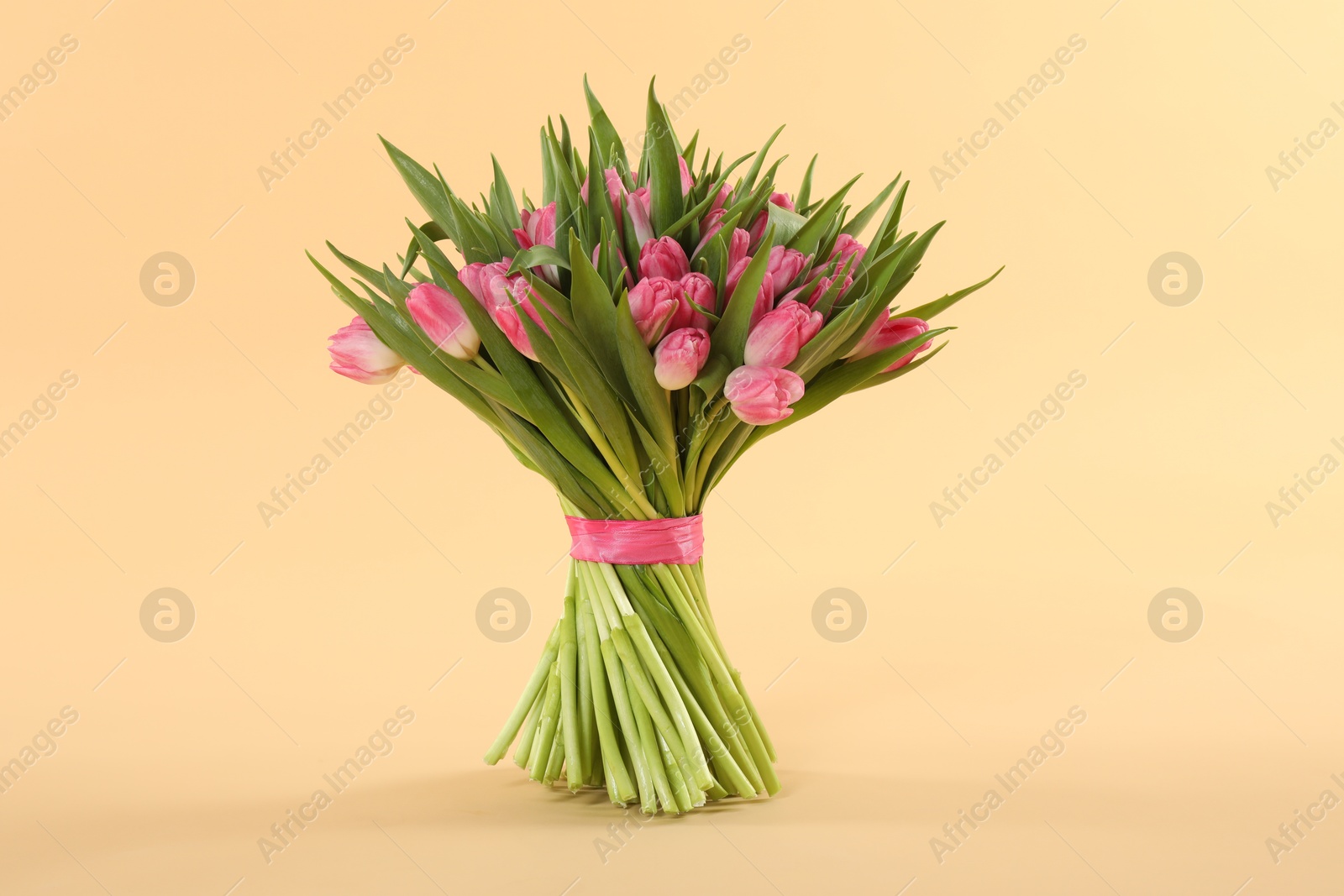 Photo of Bouquet of beautiful tulips on beige background