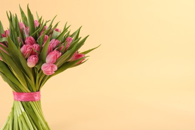 Photo of Bouquet of beautiful tulips on beige background, closeup. Space for text