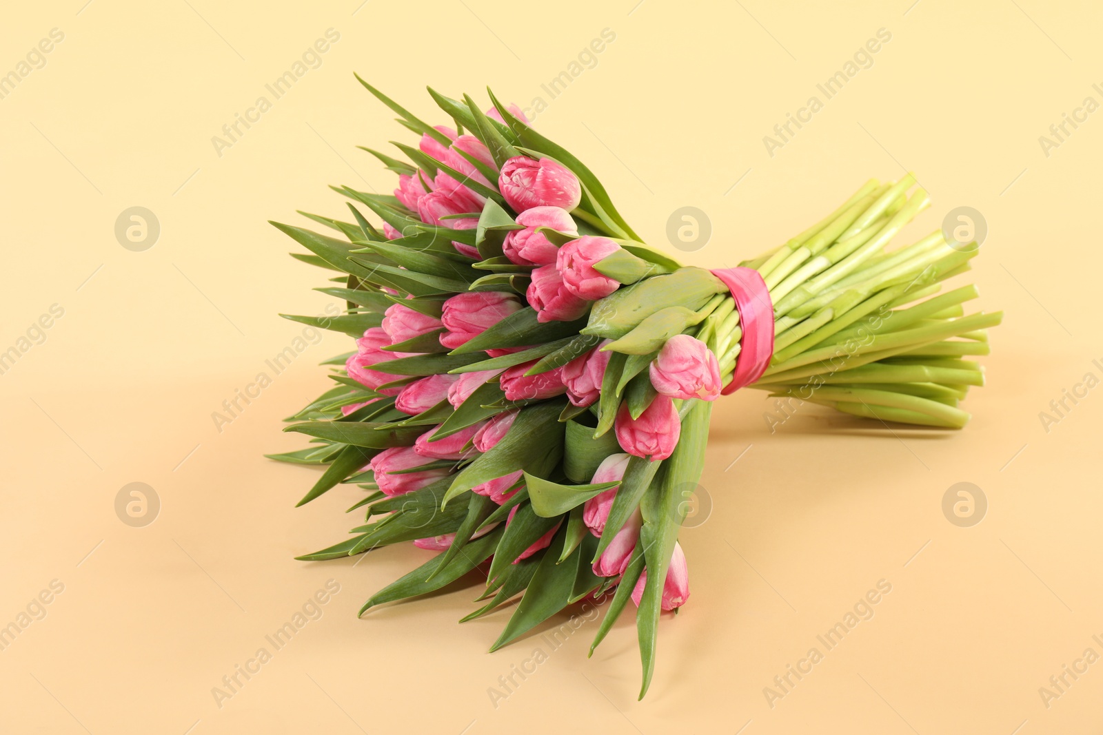 Photo of Bouquet of beautiful tulips on beige background