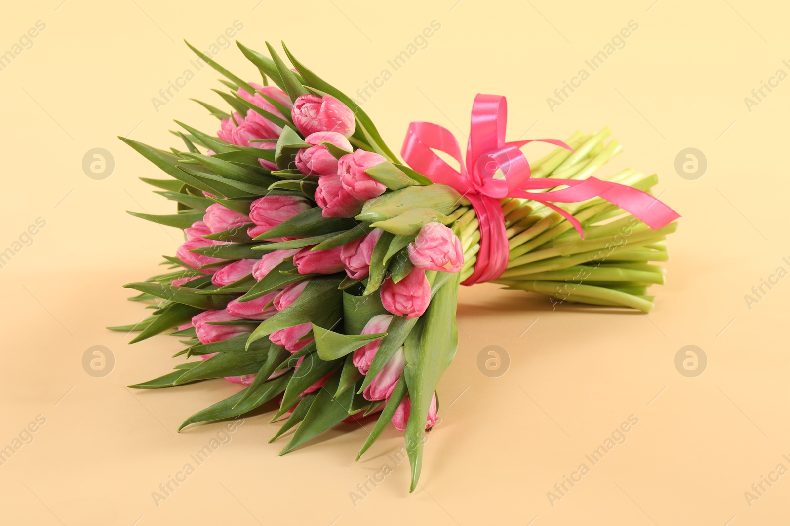 Photo of Bouquet of beautiful tulips on beige background