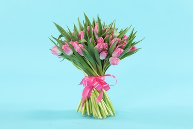 Bouquet of beautiful tulips on light blue background