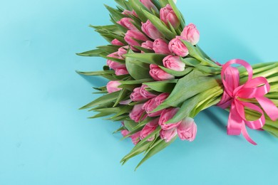 Bouquet of beautiful tulips on light blue background, top view. Space for text