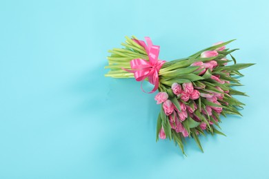 Photo of Bouquet of beautiful tulips on light blue background, top view. Space for text