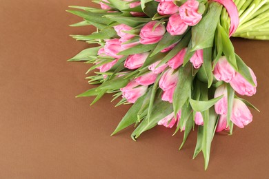 Bouquet of beautiful tulips on brown background, closeup. Space for text