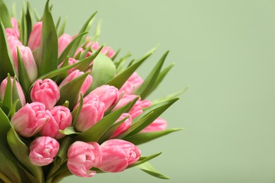 Photo of Bouquet of beautiful tulips on pale green background, closeup. Space for text