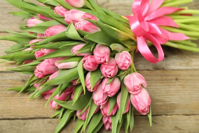 Photo of Bouquet of beautiful tulips on wooden table, closeup