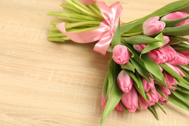 Photo of Bouquet of beautiful tulips on wooden table, closeup. Space for text