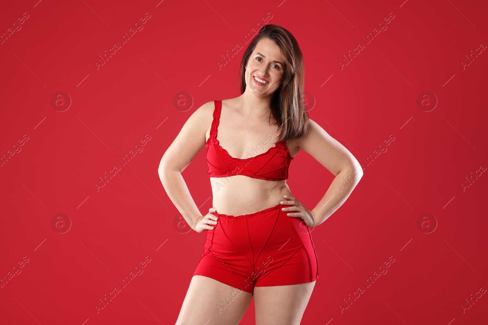 Photo of Woman in underwear on red background. Cellulite problem