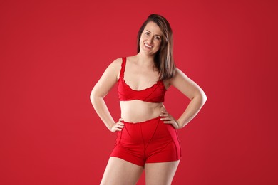 Woman in underwear on red background. Cellulite problem