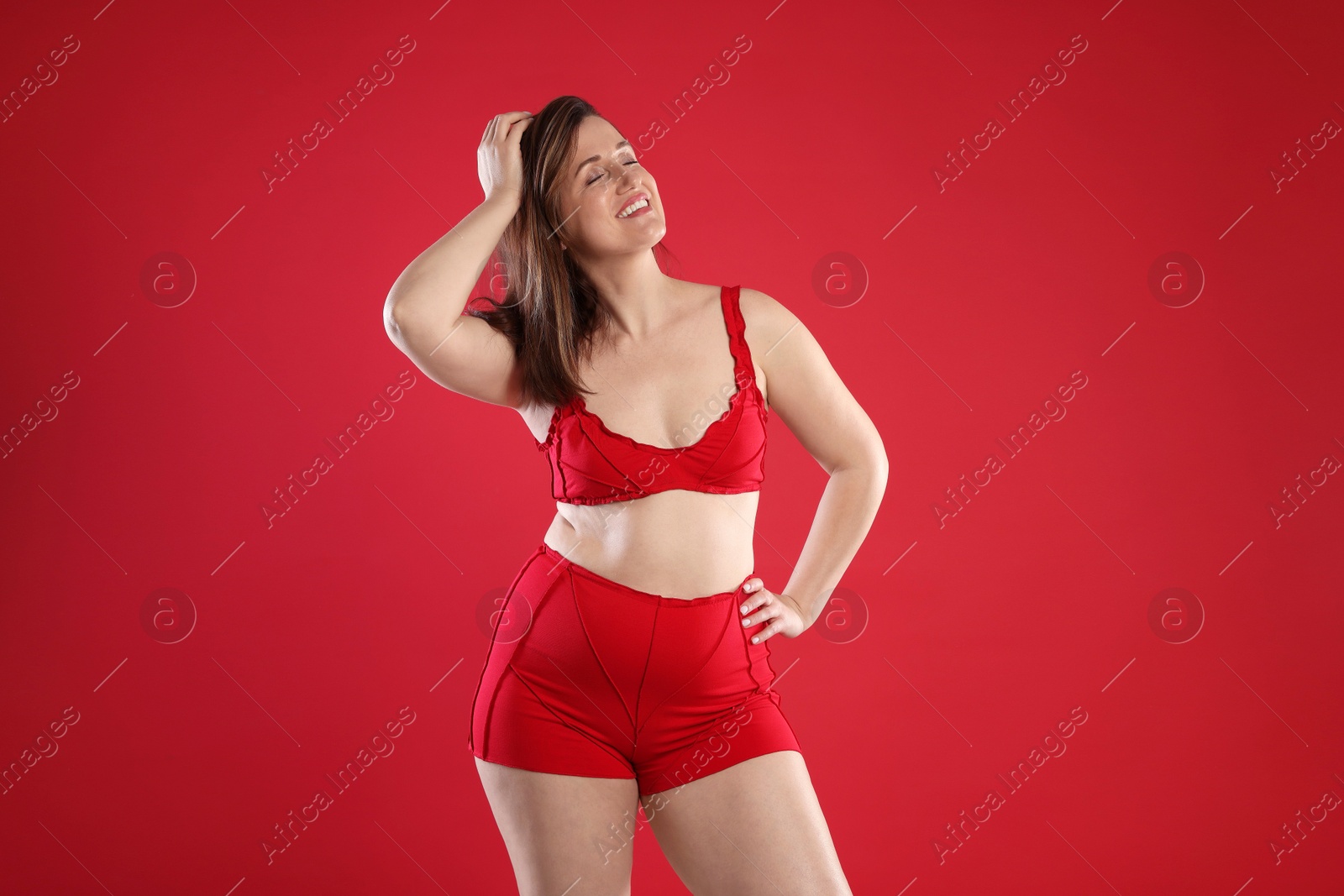 Photo of Woman in underwear on red background. Cellulite problem