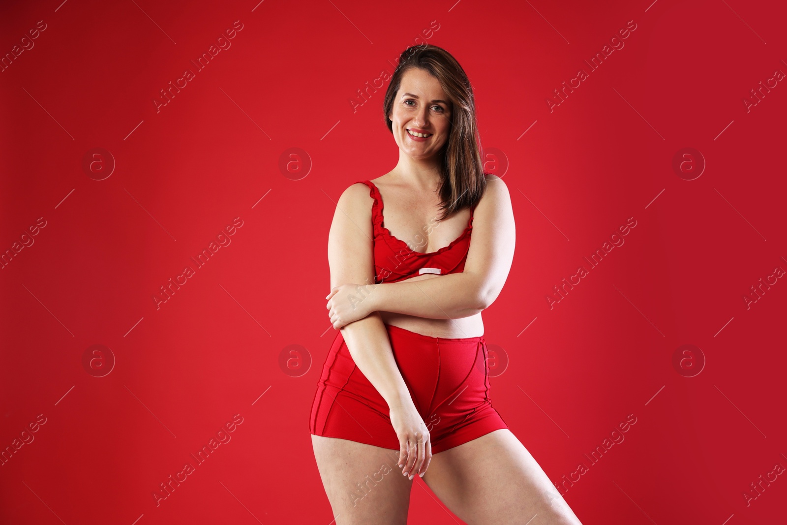 Photo of Woman in underwear on red background, space for text. Cellulite problem