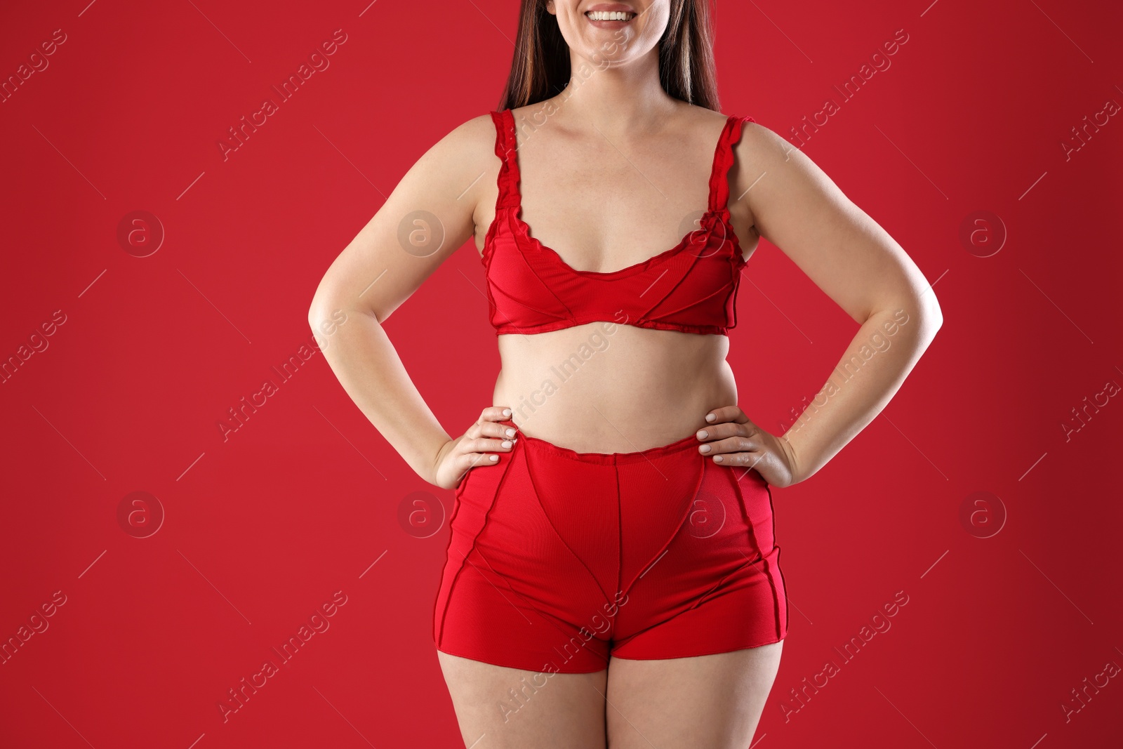 Photo of Woman in underwear on red background, closeup. Cellulite problem