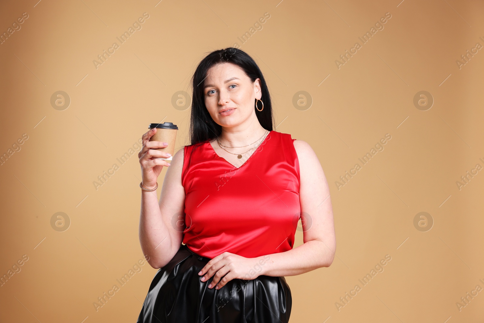 Photo of Charming plus size model with paper cup on beige background. Overweight