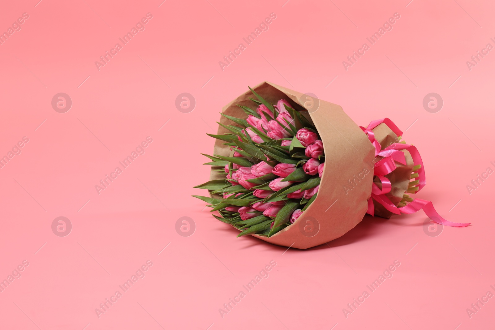 Photo of Bouquet of beautiful tulips on pink background, space for text