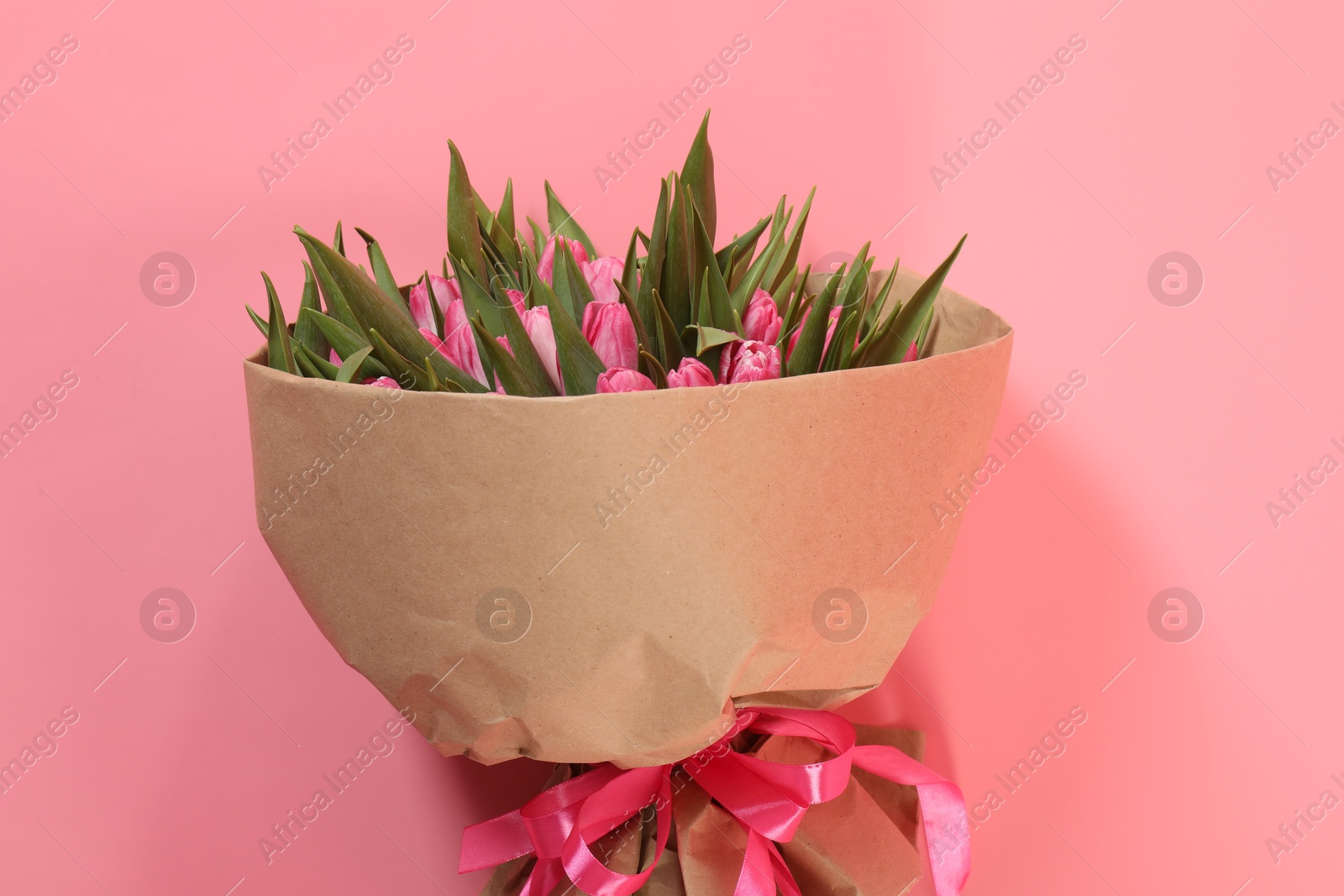 Photo of Bouquet of beautiful tulips on pink background, top view