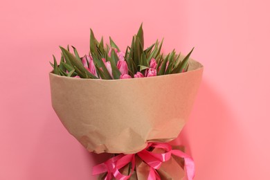 Bouquet of beautiful tulips on pink background, top view