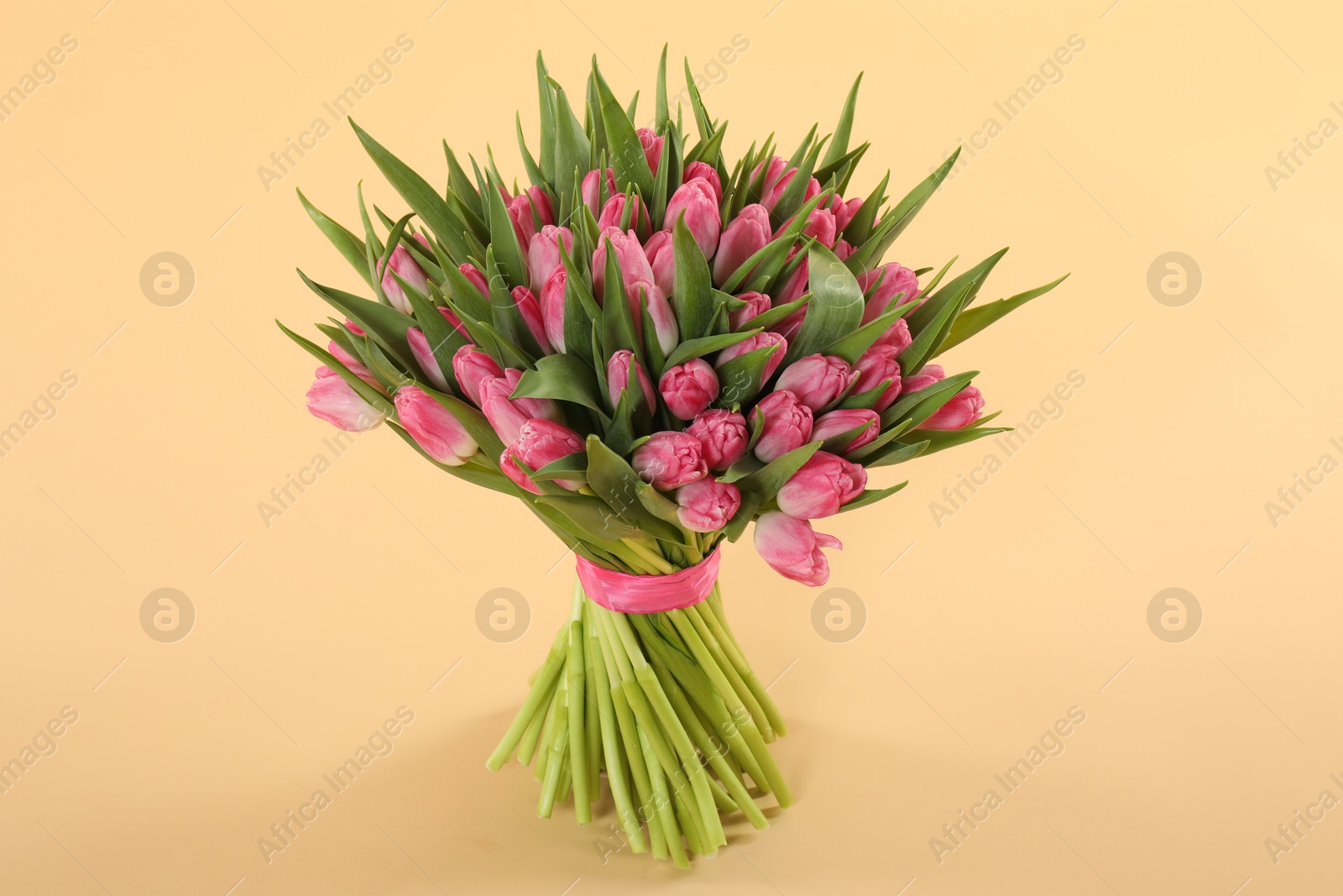 Photo of Bouquet of beautiful tulips on beige background