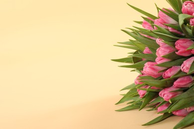 Photo of Bouquet of beautiful tulips on beige background, closeup. Space for text