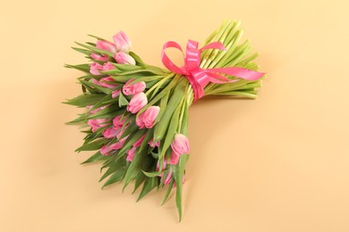 Photo of Bouquet of beautiful tulips on beige background, above view