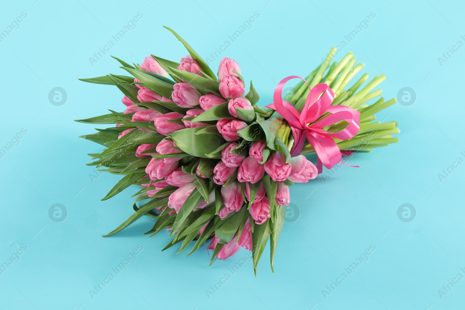 Photo of Bouquet of beautiful tulips on light blue background