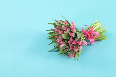 Photo of Bouquet of beautiful tulips on light blue background, space for text