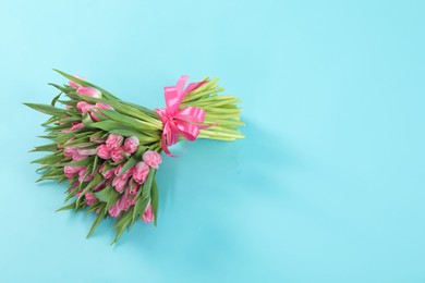 Photo of Bouquet of beautiful tulips on light blue background, top view. Space for text