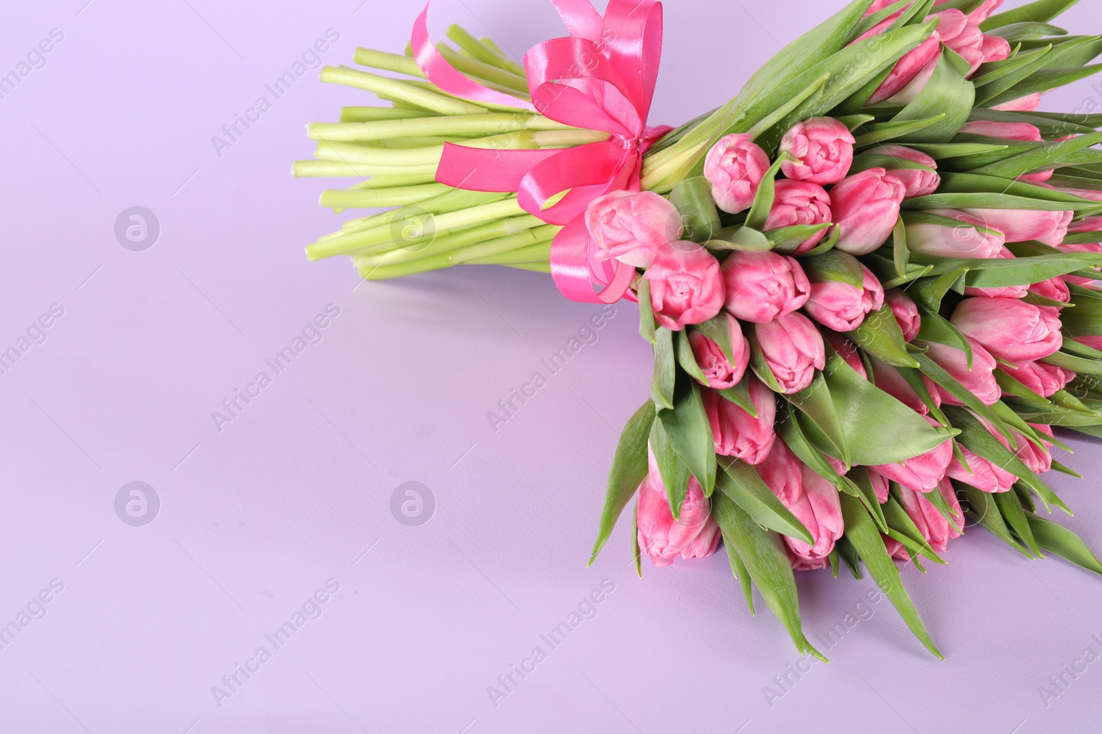 Photo of Bouquet of beautiful tulips on lilac background, closeup. Space for text