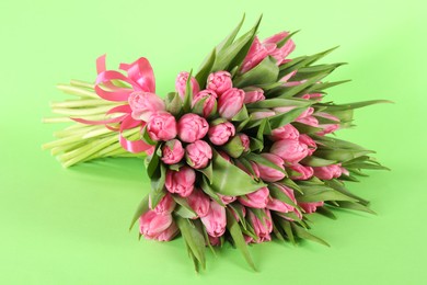 Bouquet of beautiful tulips on green background