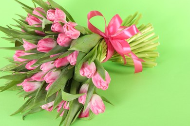 Photo of Bouquet of beautiful tulips on green background, closeup. Space for text