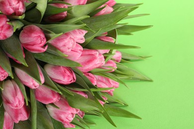 Photo of Bouquet of beautiful tulips on green background, closeup. Space for text