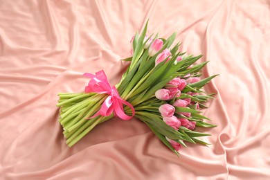 Bouquet of beautiful tulips on silk fabric, above view