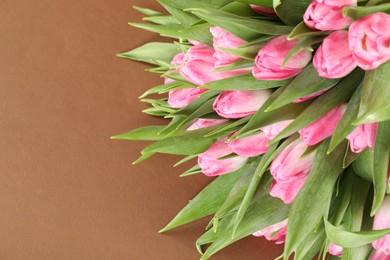 Photo of Bouquet of beautiful tulips on brown background, closeup. Space for text